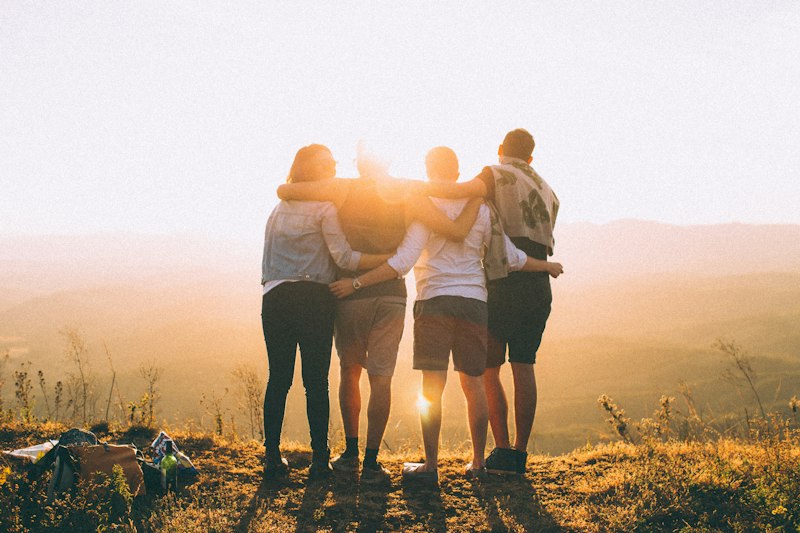 Chosen family holding hands at sunset